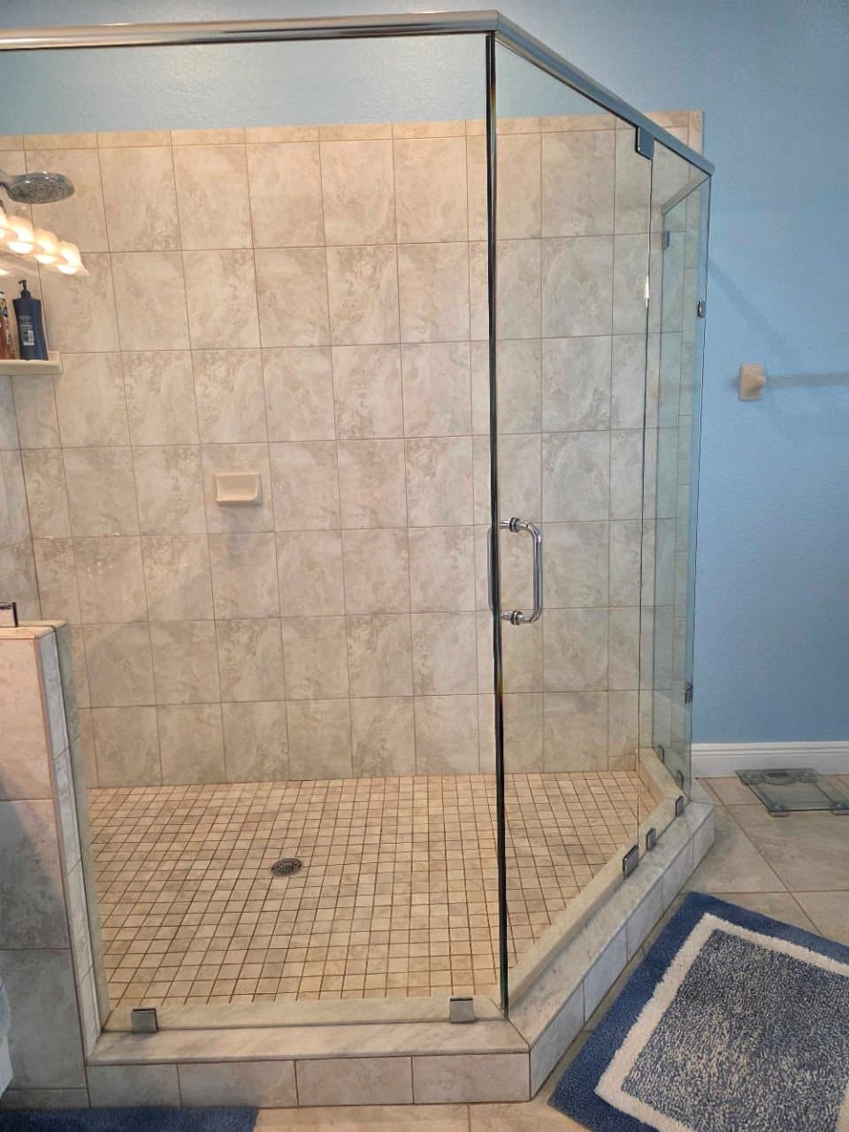 Glass shower with travertine tile after a deep clean